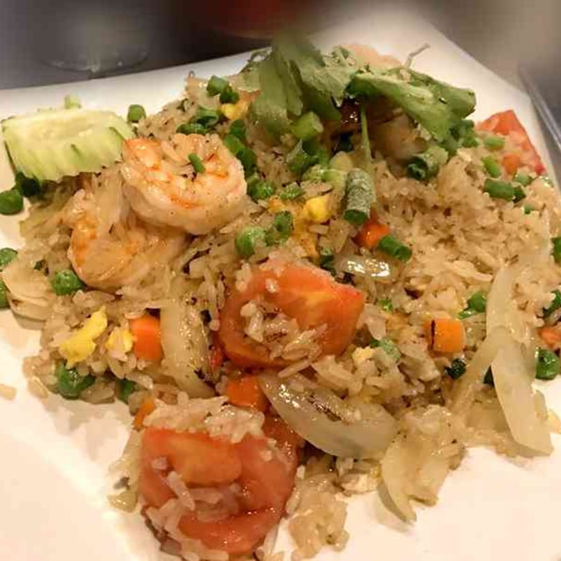 Tong Thai's shrimp fried rice with vegetables, garnished with fresh cilantro and cucumber.