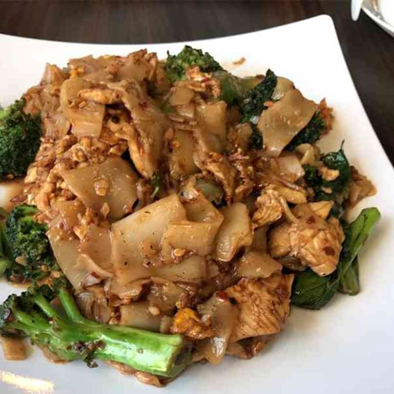 Tong Thai's Pad See Ew with wide noodles, chicken, and broccoli on a white plate.